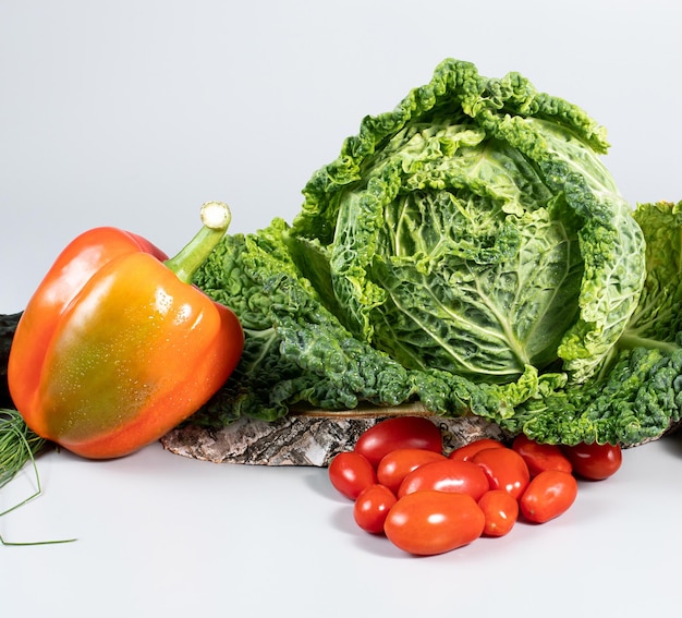 Frischer Wirsingkohl Paprika grüne Zwiebel Tomaten auf grauem Hintergrund Draufsicht Detox-Konzept vegane Lebensmittel Kochzutaten