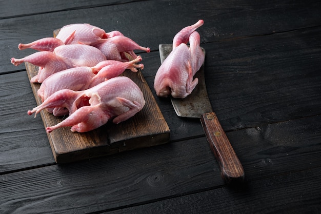 Frisches Bio-Wachtelfleisch auf schwarzem Holztisch