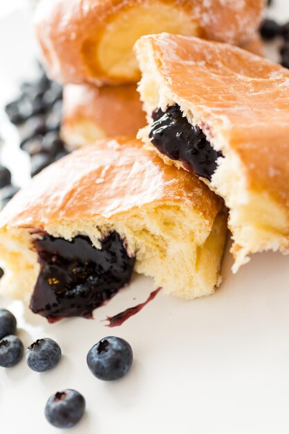 Frisches Blaubeergelee gefüllte Donuts auf weißem Hintergrund.