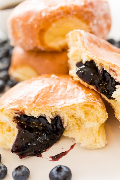 Frisches Blaubeergelee gefüllte Donuts auf weißem Hintergrund.