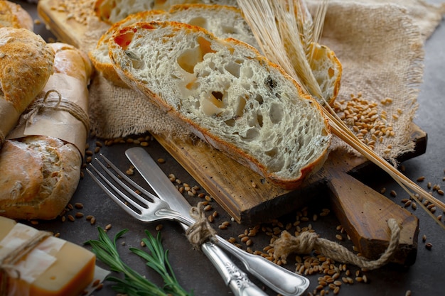 Frisches Brot auf einem alten Hintergrund mit Küchenzubehör auf dem Tisch.