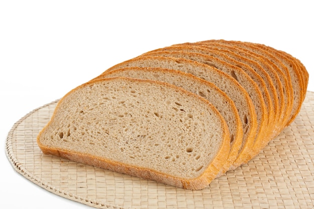 Frisches Brot, geschnitten auf einem Platzdeckchen, isoliert auf weiss
