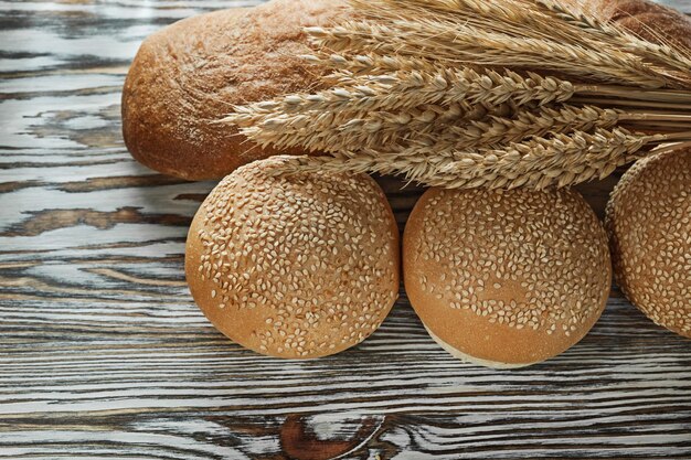 Frisches Brot, lange Laibweizenohren auf Holzoberfläche