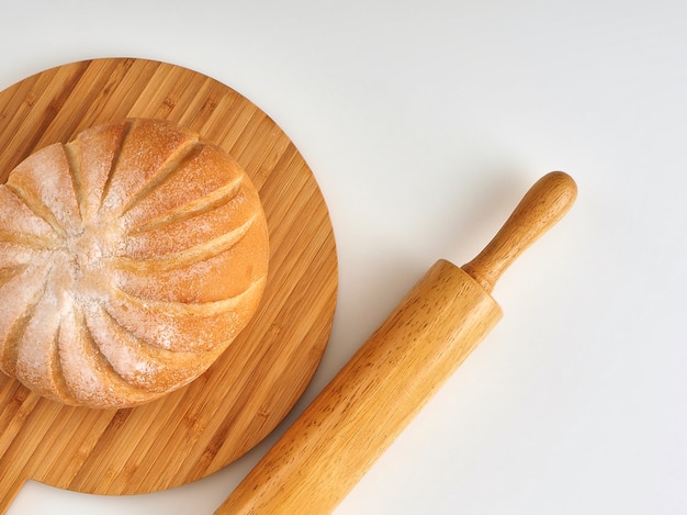Frisches Brot lokalisiert auf Weißhintergrund des hölzernen Brettes