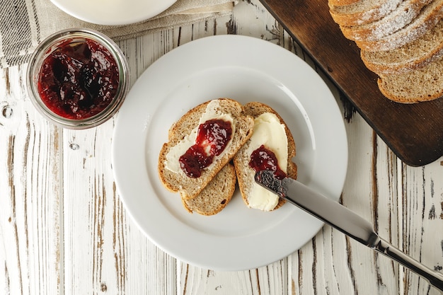 Frisches Brot mit Butter und Marmelade auf dem Tisch