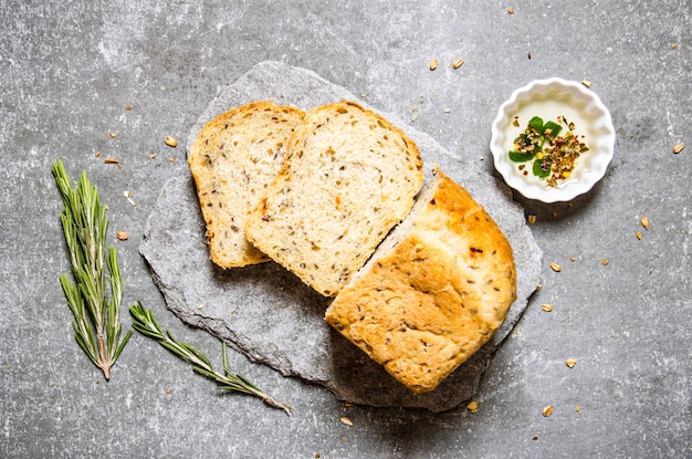 Frisches Brot mit Öl und Rosmarin. Auf dem Steintisch. Draufsicht