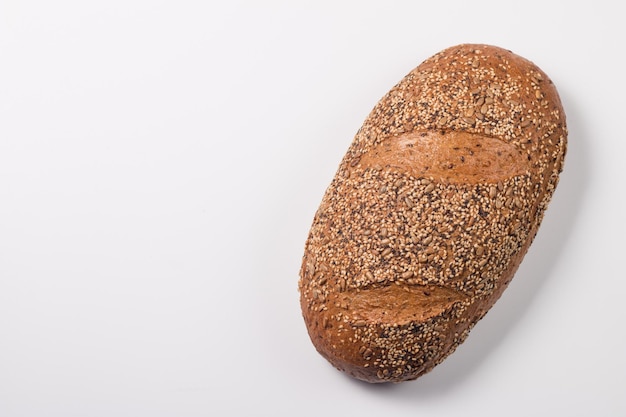 Frisches Brot mit Samen auf einem weißen Tischhintergrund. Bäckerei. Ernährungssicherheitskonzept.