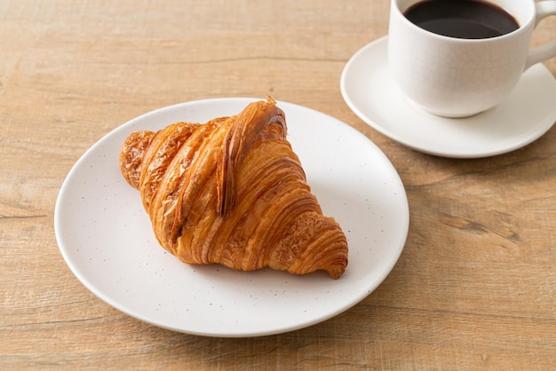 Frisches Croissant auf weißem Teller