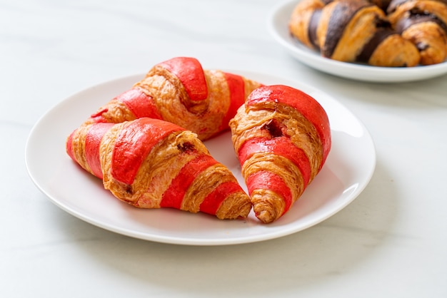 frisches Croissant mit Erdbeermarmeladensauce auf Teller