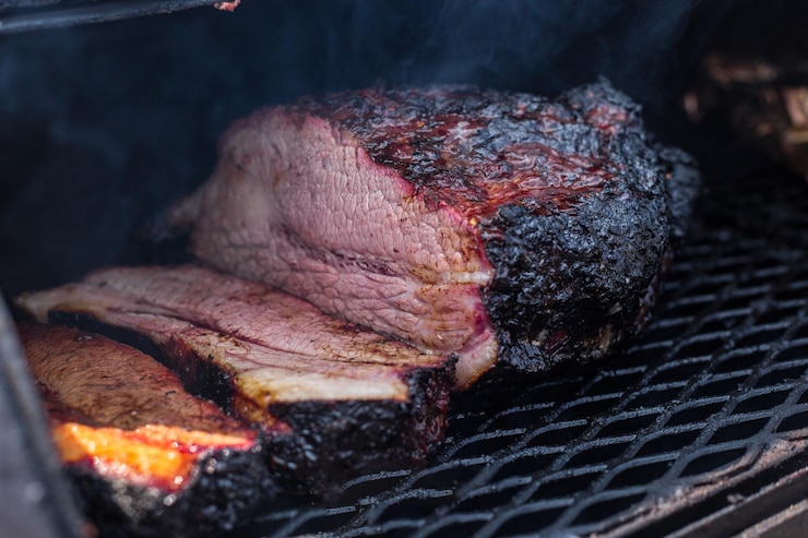 Foto frisches fleisch wird auf einem grill gegrillt