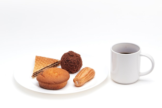 Frisches Gebäck und Desserts auf einem weißen Teller und eine Tasse Kaffee auf weißem Hintergrund