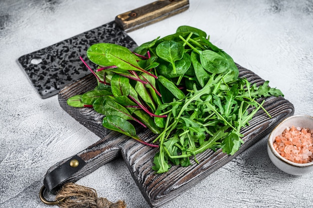 Frisches gemischtes Grün, Spinat, Mangold und Rucola. Weißer Hintergrund. Ansicht von oben.