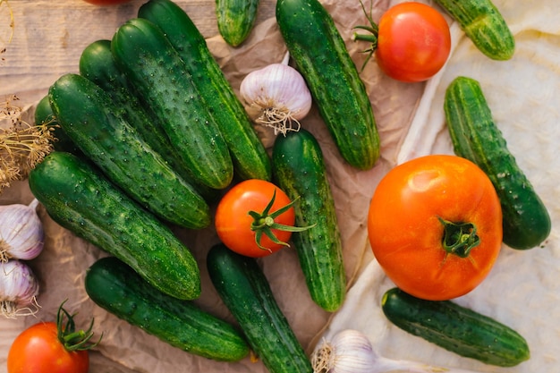 Frisches Gemüse auf einem hölzernen Hintergrund Das Konzept der gesunden Ernährung Gurken Tomaten Knoblauch Dill Ansicht von oben