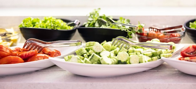 Frisches Gemüse, Gurken, Tomaten und Salat in Schüsseln auf dem Buffettisch im Hotelrestaurant