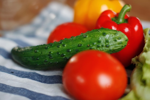 Frisches Gemüse: Tomaten, grüne Gurke, roter bulgarischer Pfeffer auf dem Tisch