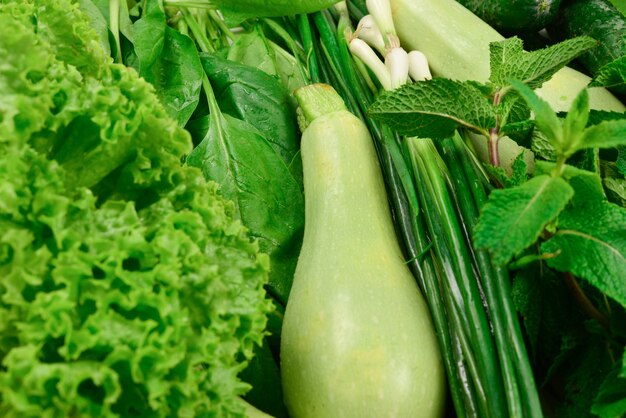 Frisches grünes Gemüse und Kräuter als Hintergrund.