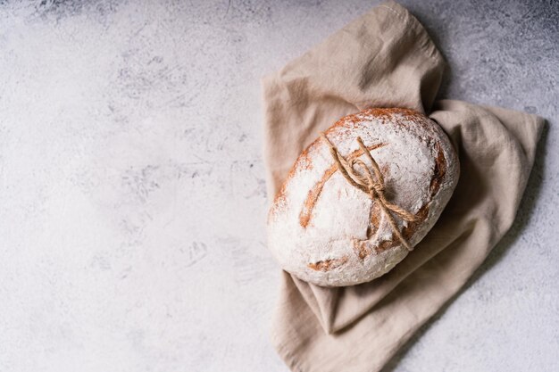 Frisches, hausgemachtes Bio-Ciabatta-Brot mit Kräutern, Olivenöl und Oliven auf weißem, rustikalem Hintergrund