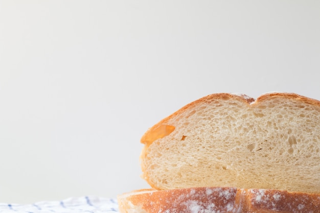Frisches hausgemachtes Brot auf weißem Tabellenhintergrund mit Serviette.