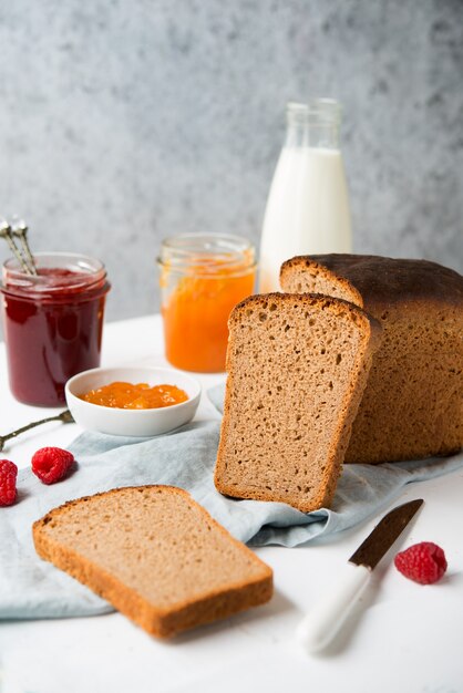 Frisches hausgemachtes brot mit marmelade und milch, hausgemachtes einfaches essen, heller hintergrund