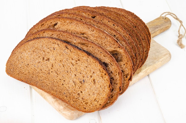 Frisches hausgemachtes Gebäck. Geschnittenes Roggenbrot auf hölzernem Hintergrund. Studiofoto.