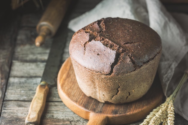 Frisches hausgemachtes traditionelles Roggenbrot auf rustikalem Holzhintergrund