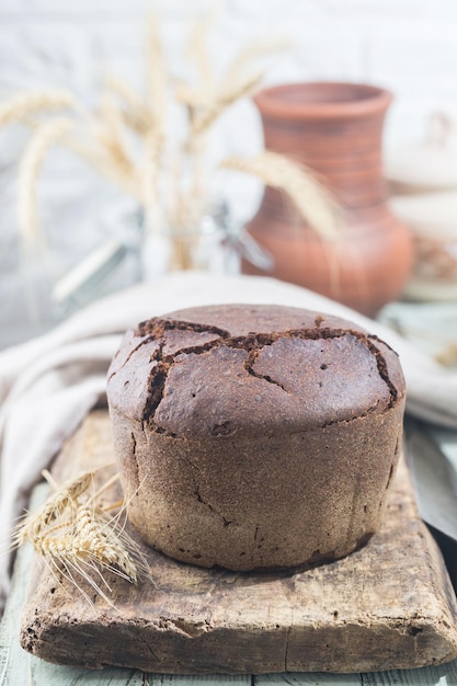 Frisches hausgemachtes traditionelles Roggenbrot auf rustikalem Holzhintergrund