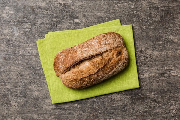 Frisches hausgemachtes Vollkornbrot Brot auf Serviette auf rustikalem Hintergrund Draufsicht des frischen Brotes