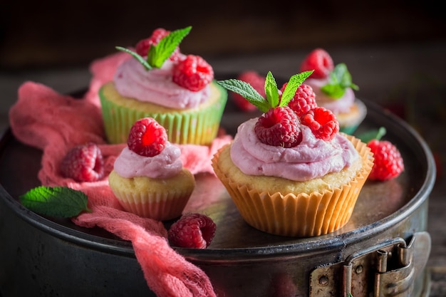 Frisches Himbeermuffin mit Beeren und rosa Sahne