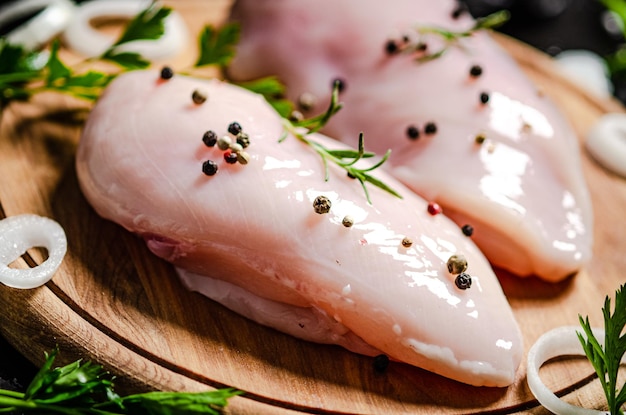 Frisches Hühnchenfilet mit Gewürzen auf einem Holztisch