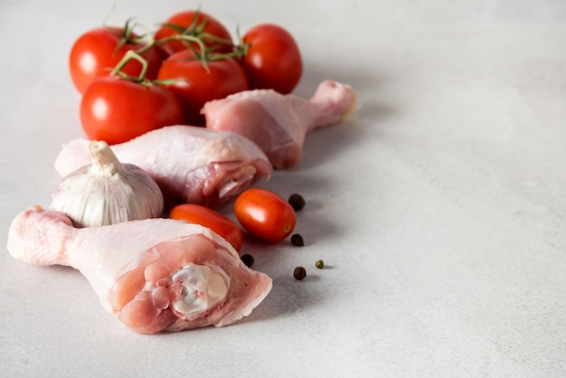 Frisches Hühnerfleisch auf grauem Hintergrund Rohe Tomaten Pfeffer Zutaten für gesundes Abendessen Kopierraum