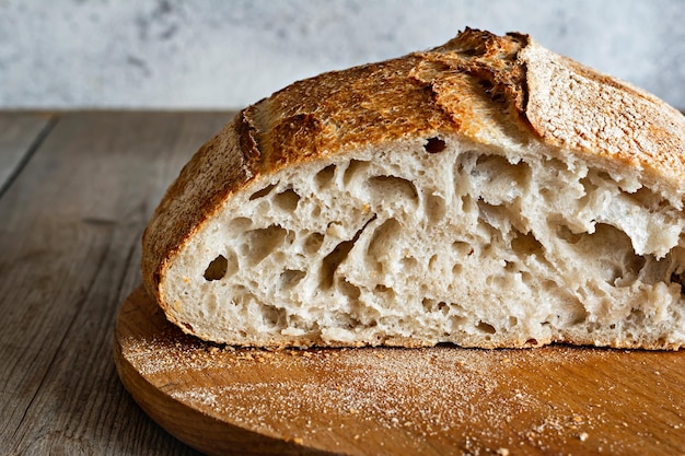 Frisches knuspriges hausgemachtes Brot mit Vollkornmehlsauerteig auf Holzgrund