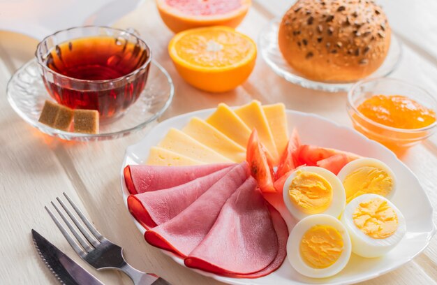 Frisches köstliches Frühstück und Tasse Kaffee oder Tee auf hellem hölzernem Hintergrund