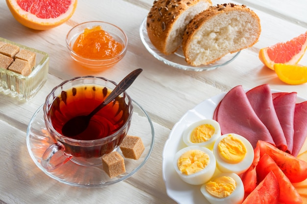 Foto frisches köstliches frühstück und tasse kaffee oder tee auf hellem hölzernem hintergrund
