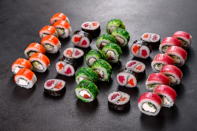 Frisches köstliches Sushi rollt auf einem dunklen Hintergrund