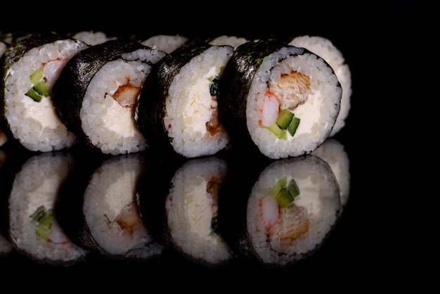 Frisches köstliches Sushi rollt auf einem dunklen Hintergrund