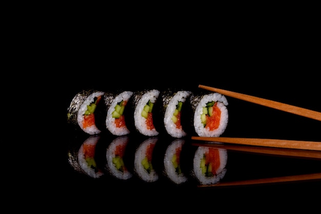 Frisches köstliches Sushi rollt auf einem dunklen Hintergrund