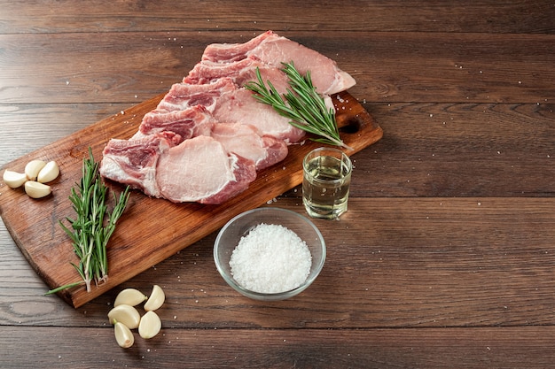 Frisches lendensteak aus rohem fleisch und gewürzen und einem messer liegt auf holz., flach