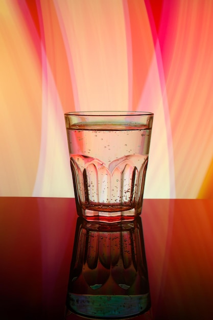 Frisches modernes facettiertes Glas auf dem farbigen Hintergrund