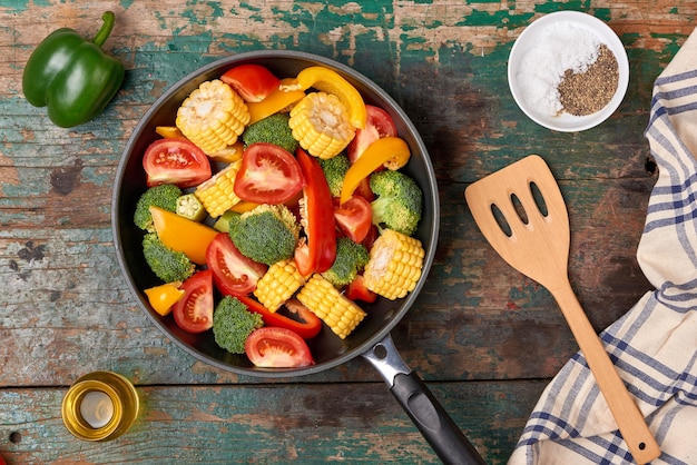 Frisches Obst und Gemüse auf einer Bratpfanne auf einem alten Holzhintergrund