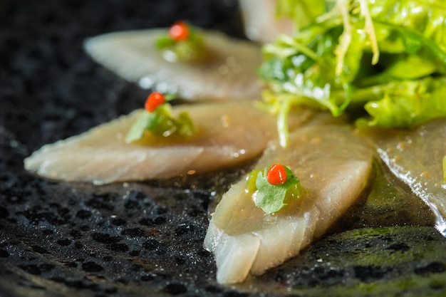 Frisches organisches weißes Thunfischfleisch, das auf Teller mit Salat geschnitten wird