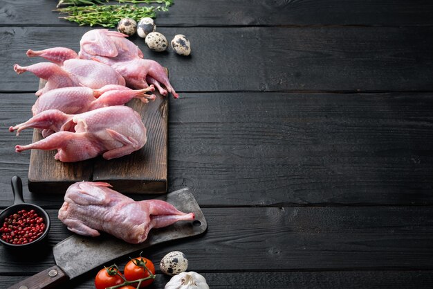 Frisches rohes Fleisch Wachteln mit Kräutern, auf schwarzem Holztisch