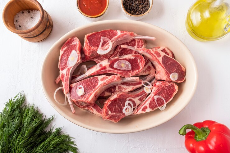 Foto frisches rohes hammelfleisch am knochen mit zutaten zum marinieren und kochen. draufsicht