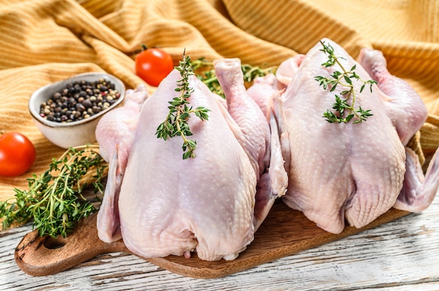 Frisches rohes Huhn mit Gewürzen, kochendem Hintergrund auf Weiß. Draufsicht