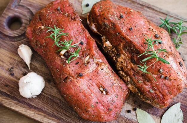 Frisches rohes mariniertes Fleisch auf einem Holztisch.