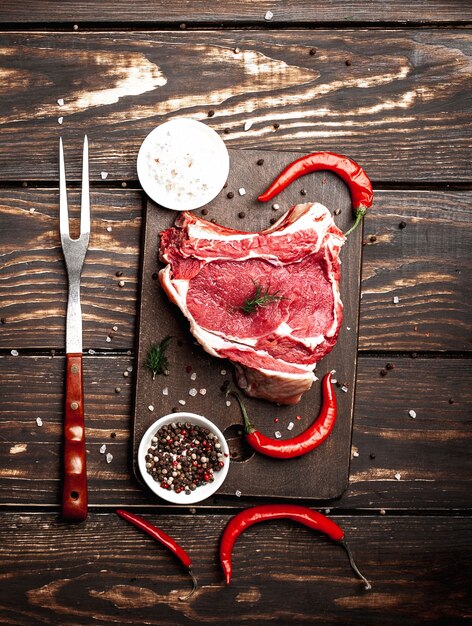 frisches rohes Rindersteak auf Holzschneidebrett