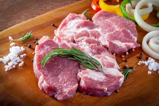 Frisches rohes Schweinefleisch auf hölzernem Hintergrund.