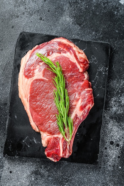 Frisches rohes Steak mit Gewürzen auf dem Tisch