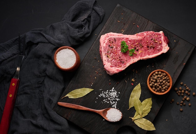 Frisches rohes Stück Rindfleisch Striploin Steak auf schwarzem Hintergrund Draufsicht Marmoriertes Stück Fleisch