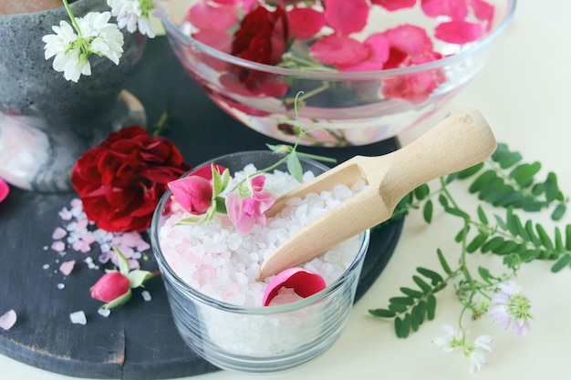 Frisches rosa und violettes Rosenwasser und Meersalz mit Blütenblättern Naturkosmetik