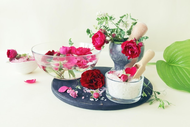 Frisches rosa und violettes Rosenwasser und Meersalz mit Blütenblättern Naturkosmetik